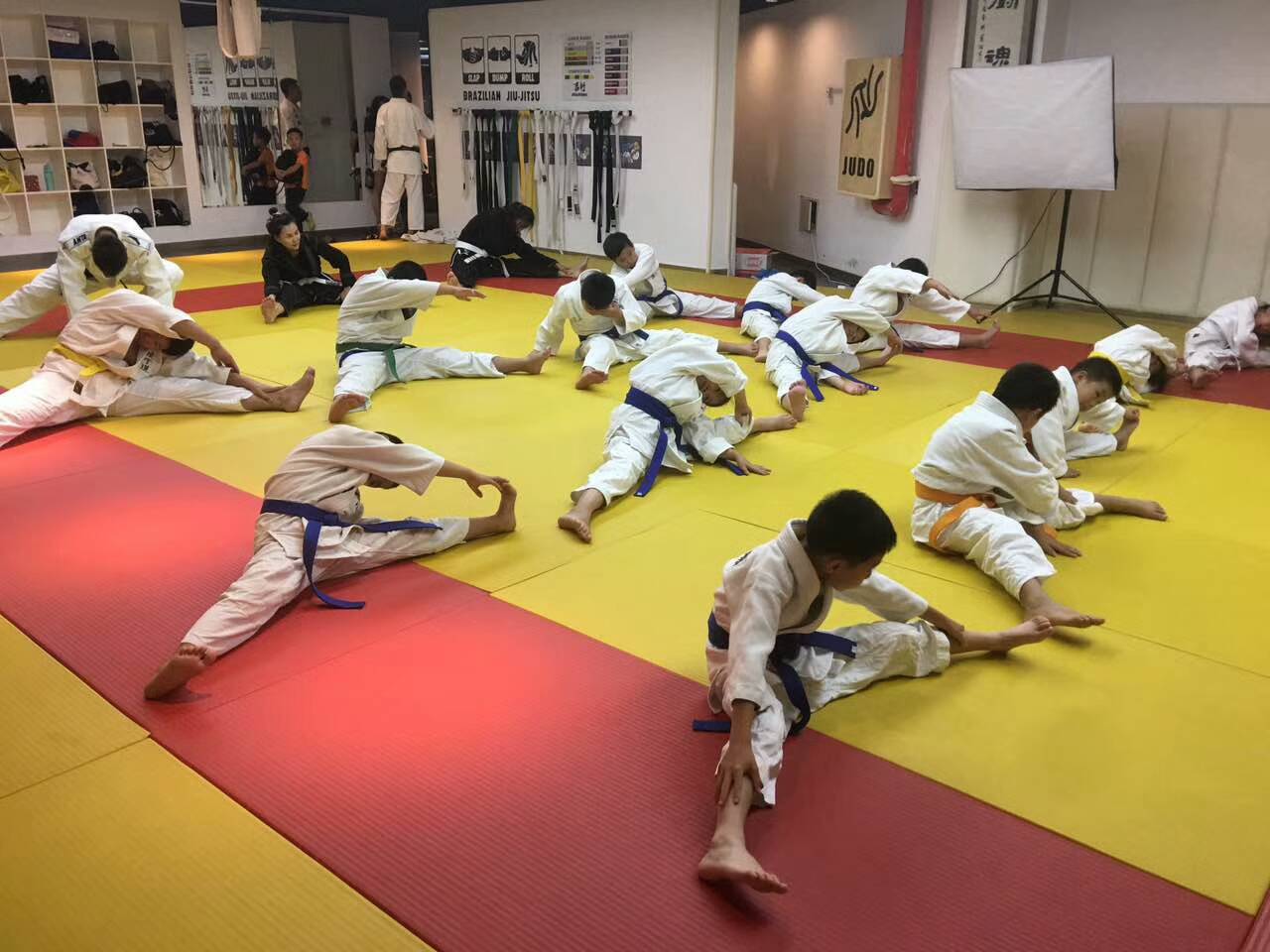 Students stretching on the mat inside Ji Yu Dao judo dojo